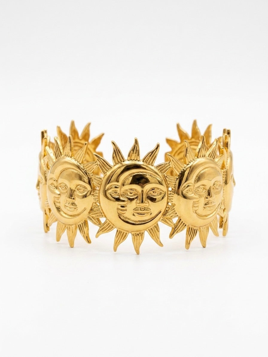 bracelet manchette dorée à motifs soleils et croissants de lune sculptés
