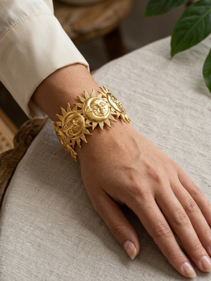 bracelet manchette dorée à motifs soleils et croissants de lune sculptés porté