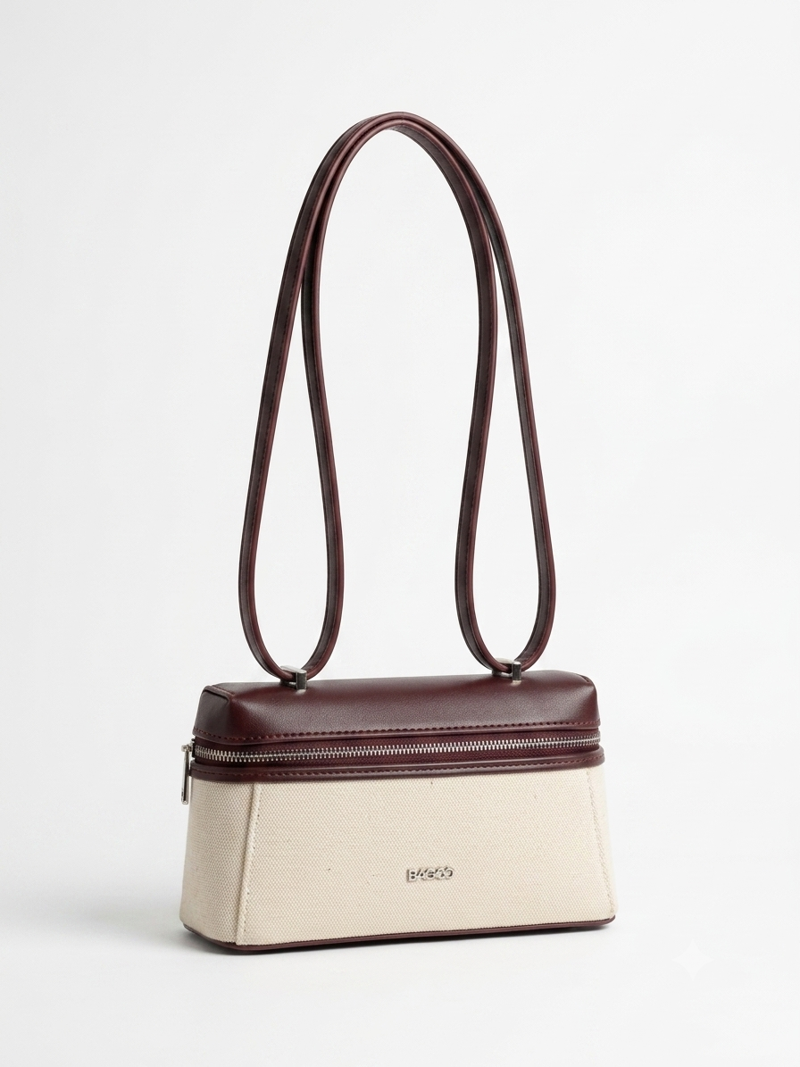 Sac à main structuré bicolore beige et bordeaux, avec longues anses fines, fermeture zippée sur le dessus et design élégant minimaliste.