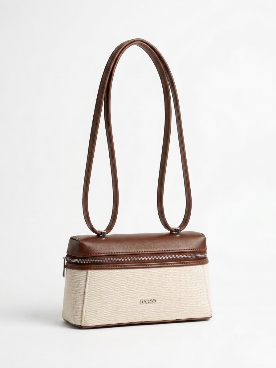 Sac à main structuré bicolore beige et marron, avec longues anses fines, fermeture zippée sur le dessus et design élégant minimaliste.