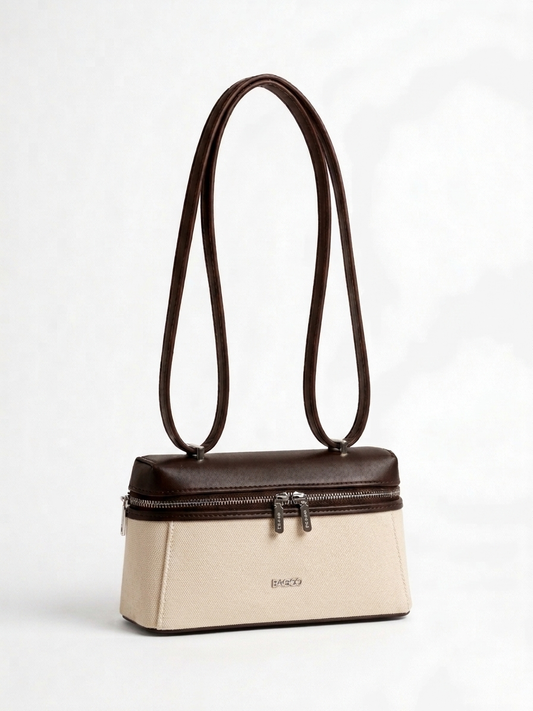 Sac à main structuré bicolore beige et marron foncé, avec longues anses fines, fermeture zippée sur le dessus et design élégant minimaliste.