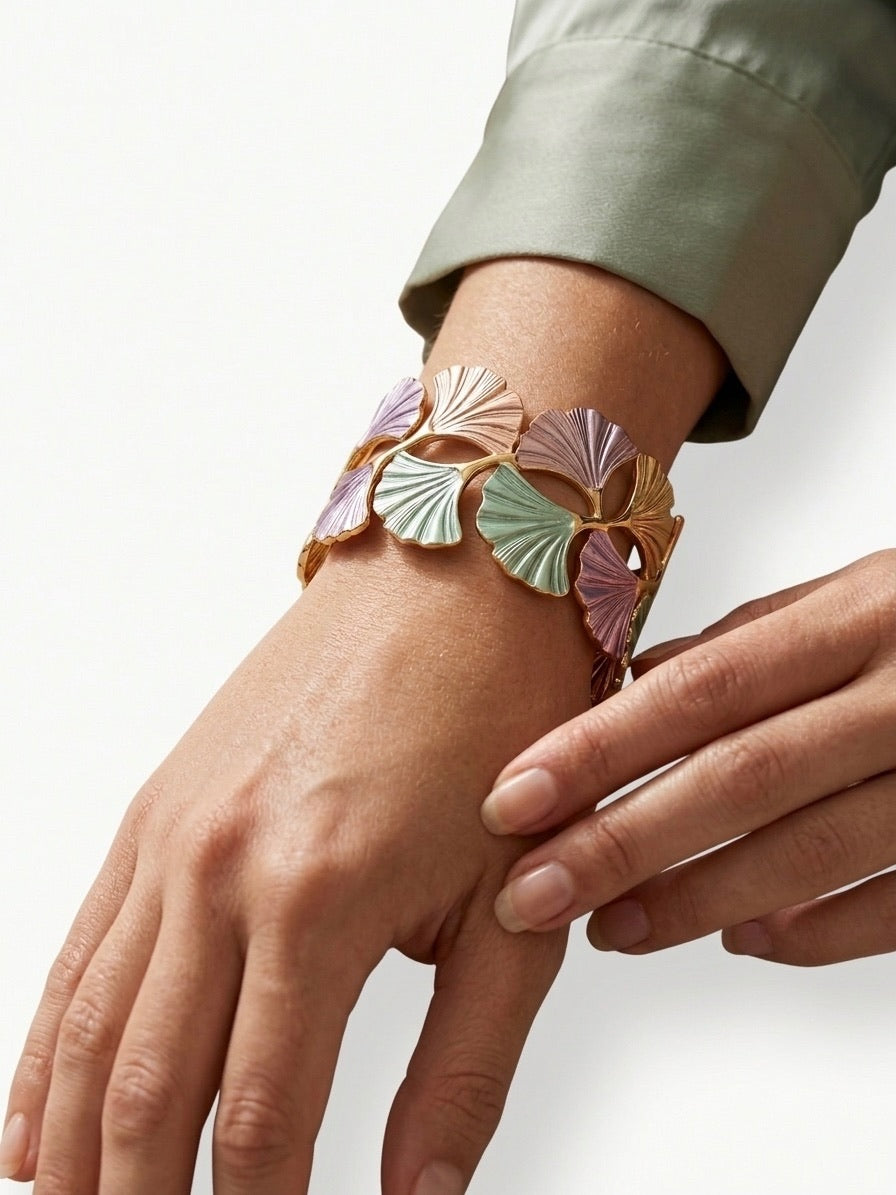 bracelet manchette doré avec feuilles de ginkgo biloba pastel violettes et vertes porté au poignet