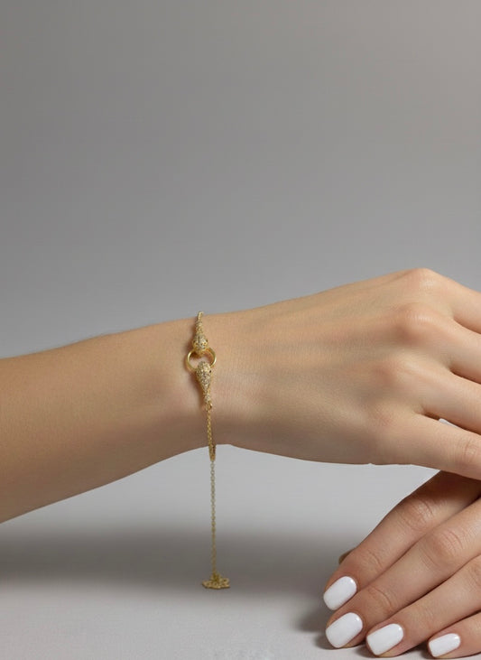 bracelet en acier inoxydable doré ayant deux serpents attché à un anneau 