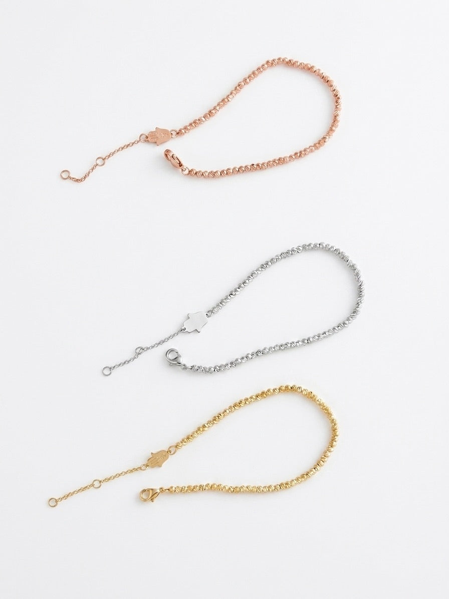 Lot de trois bracelets en acier inoxydable. Porté élégant. Couleurs doré, argenté et rose gold