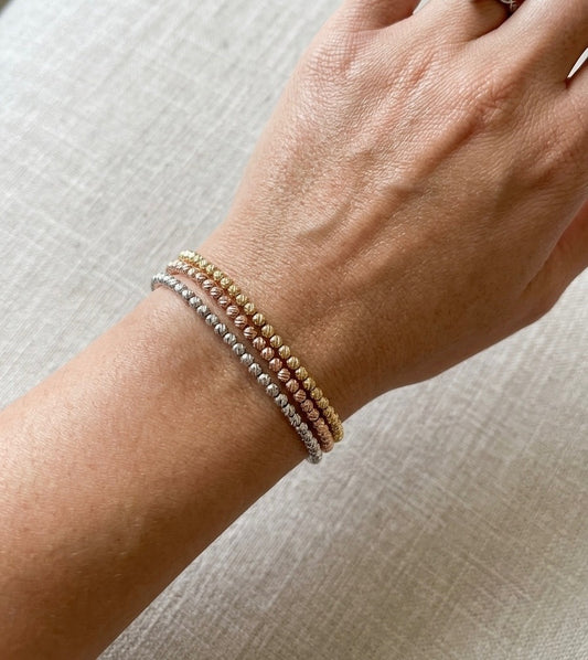 Lot de trois bracelets en acier inoxydable. Porté élégant. Couleurs doré, argenté et rose gold