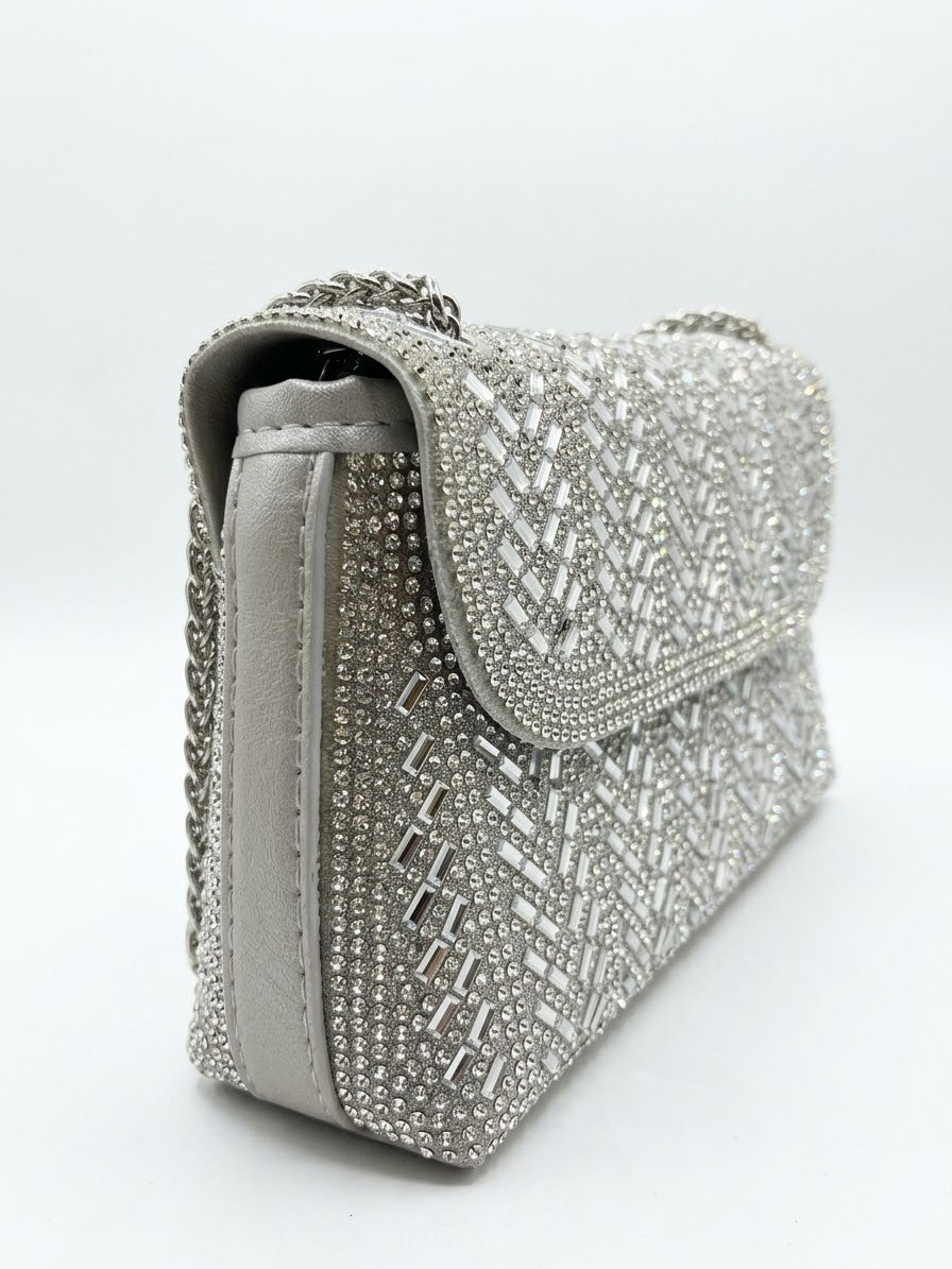 Sac à main de coté argenté à strass avec motif géométrique et chaîne tressée.